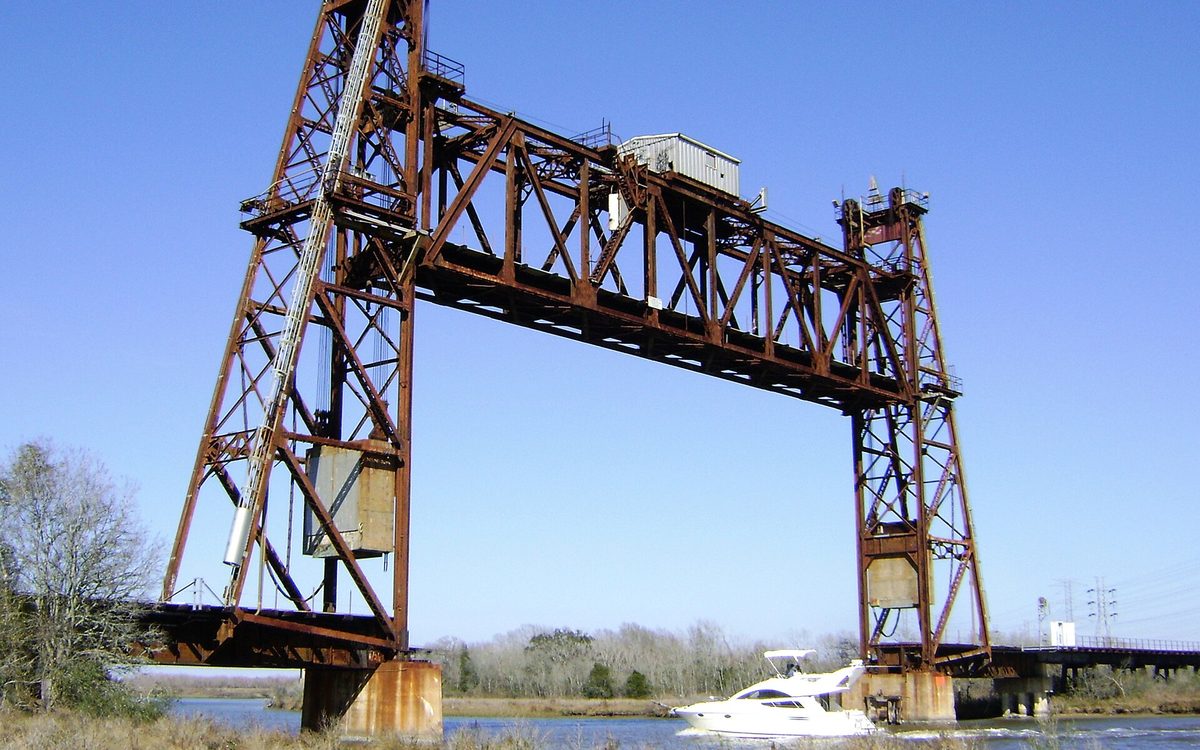 Abandoned truss railroad lift bridge over over Cedar Bayou, south of Spur 55, Baytown, Texas. As the bridge is no longer in use, it is locked permanently in the raised position.