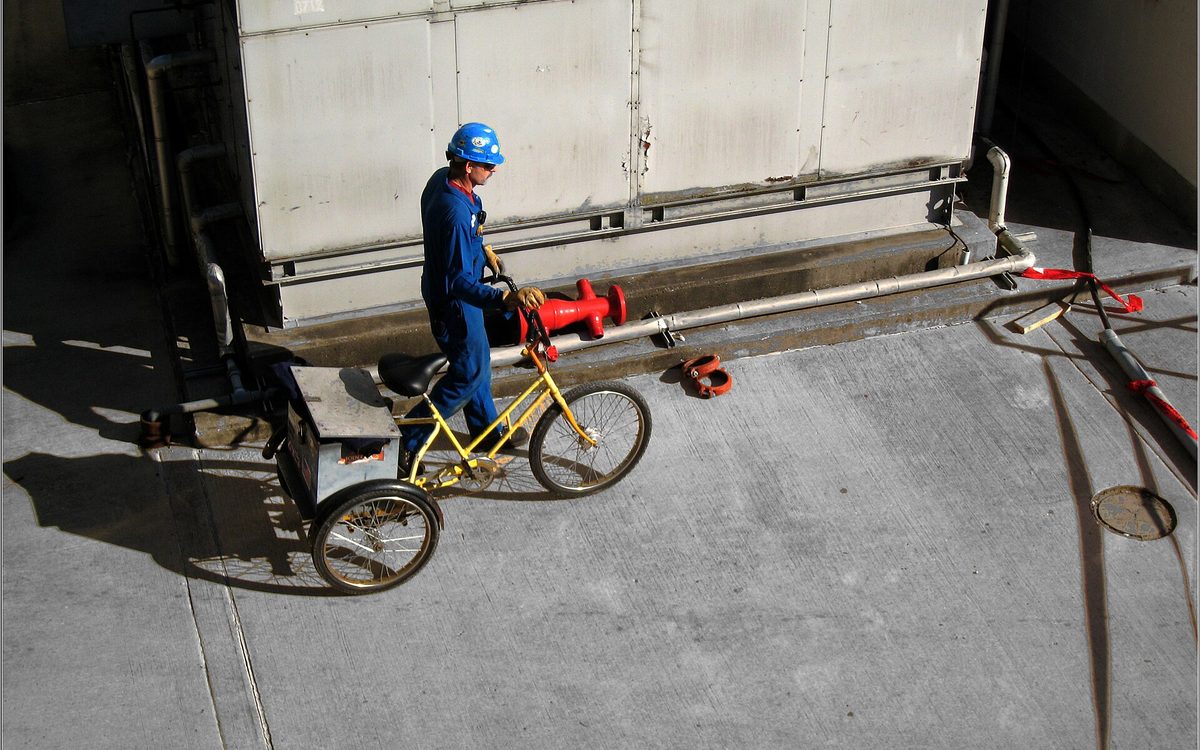 A Petrochemical worker walks beside his three-wheeled bicycle near Baytown, Texas.