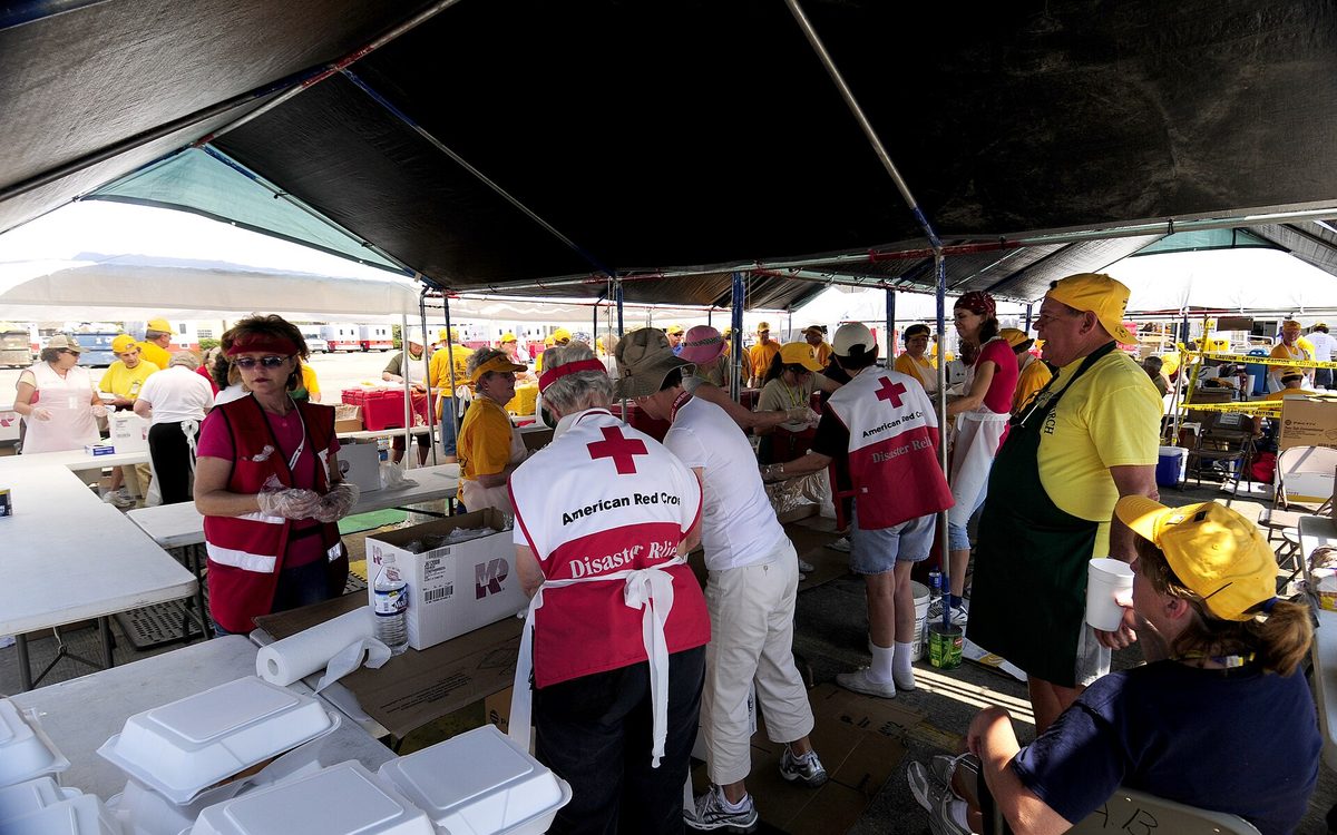 Baytown, TX, September 28, 2008 -- Members of the American Red Cross working side by side with the North Carolina Baptist Men Convention (in yellow shirts) to distribute meals to local residents recovering from Hurricane Ike. These mobile kitchens are capable of serving 70,000 meals per day; two weeks after the storm 7000 meals/day are still being served. Mike Moore/FEMA