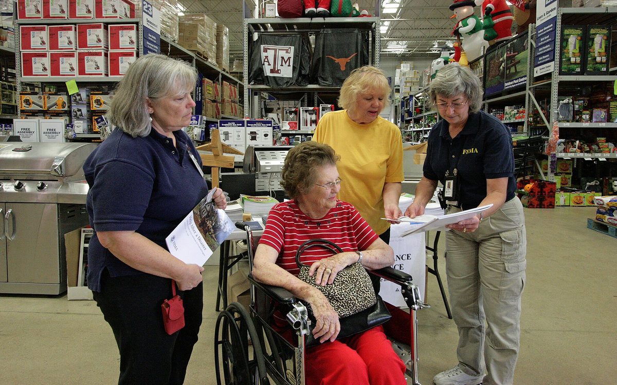 Baytown, TX, October 13, 2008 -- FEMA Mitigation Specialists Kitty Lyons (left) and Kathleen Rhodes (right) talk with Gaytha Garland and her daughter Gayle at a home improvement store.  FEMA provides mitigation information to residents so they can take measures to reduce the risk of property damage from future disasters.  Photo by Greg Henshall / FEMA