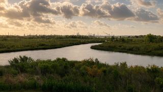 a bayou winding through green prairie